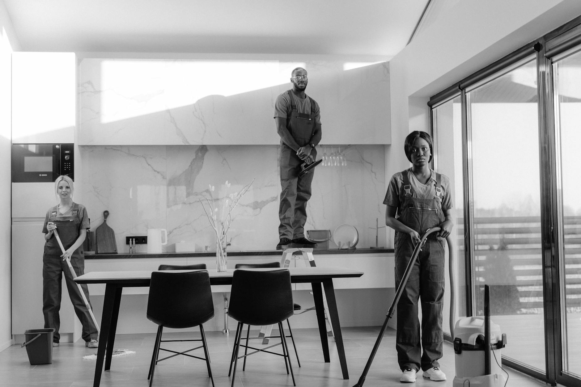 A team of professional cleaners working in a modern dining room setting, enhancing interior cleanliness.